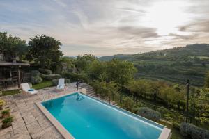 an outdoor swimming pool with a view of the hills at Villa Belle in Oprtalj