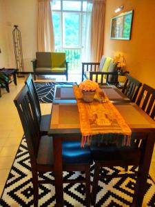 uma mesa de jantar com cadeiras e uma sala de jantar em Jean CleanComfy Apt Near Beach em Batu Ferringhi