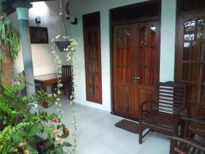Habitación con 2 puertas de madera y silla en Aayu's Guest en Bentota