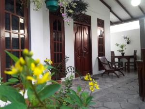 a front porch of a house with wooden doors at Aayu's Guest in Bentota