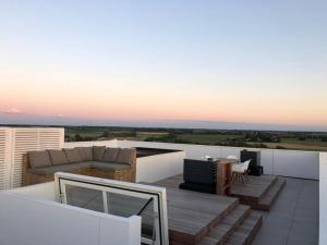a patio with a couch and a table on a roof at Penthouse in Badhuis Cadzand in Cadzand