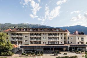 a large hotel with mountains in the background at Hotel Prokulus in Naturno