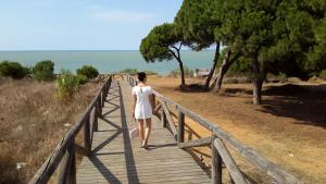 a woman walking on a wooden bridge at La Pandorga in Sanlúcar de Barrameda