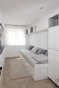 a white bedroom with a bed and white cabinets at Maria Pita in A Coruña