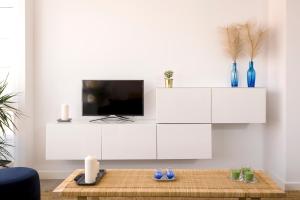 ein Wohnzimmer mit einem TV und einem weißen Schrank in der Unterkunft Maria Pita in A Coruña