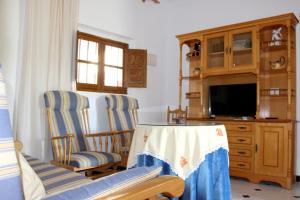 ein Wohnzimmer mit 2 Stühlen und einem TV in der Unterkunft Casa Paquita Y Telesforo in Alora