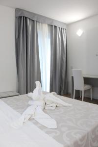 
a white towel laying on top of a white bed at Residence Hotel La Taverna in Capo Vaticano

