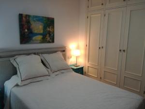 カディスにあるPegaíto a la Alamedaの白いベッドと壁に絵画が飾られたベッドルーム1室