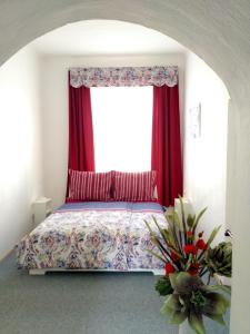 オロモウツにあるApartmán 4U Centrum + free parkingのベッドルーム1室(赤いカーテンと窓付きのベッド1台付)