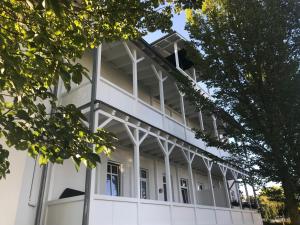 a white building with windows and trees at Meerblick Apartments Villa Vineta Göhren in Göhren