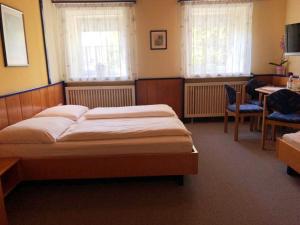 1 dormitorio con 1 cama, mesa y sillas en Gästehaus Stögmüller en Asten