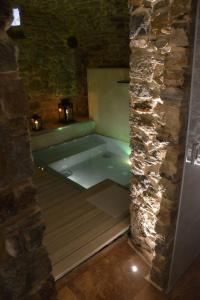 a bath tub in a room with a stone wall at B&B éve in Aosta