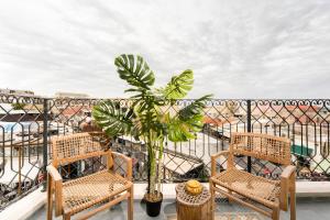 einen Balkon mit zwei Stühlen und einer Topfpflanze in der Unterkunft Heart of Jaffa's Flea Market by Five Stay in Tel Aviv