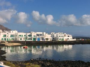 un gruppo di edifici bianchi su un corpo idrico di Apartment Orzola Vista Mar a Órzola