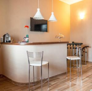 uma cozinha com um bar com cadeiras e um lavatório em B&b A casa di Maybe em Caserta