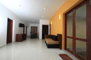 a living room with a couch and a television at Breezy Villa in Negombo