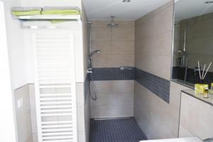 a bathroom with a shower with a glass door at Messeappartement Unterrath in Düsseldorf