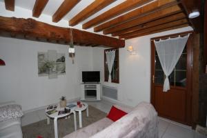 a living room with a couch and a table at Le Clos des Hortensias in Toutainville