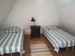 two twin beds in a room with a table at Le Clos des Hortensias in Toutainville +15 photos