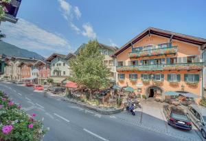 a building on a street with cars parked on the street at Gasthof Hotel Hauslwirt in Golling an der Salzach