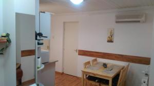 a room with a table and a kitchen with a table and chairs at Roxanna Apartman in Gyula