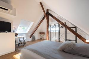 a bedroom with a bed and a staircase with a television at Design-Loft und Apartments in Mülheim an der Ruhr