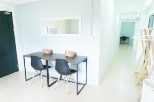 a table and two chairs in a white room at Baan Ploy In in Chiang Mai