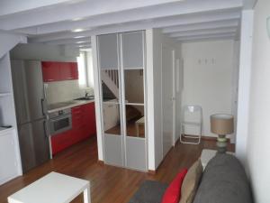 a living room with a couch and a kitchen with red cabinets at résidence Biak Bat in Ciboure