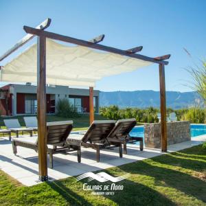 a group of chairs under a pavilion next to a pool at Colinas de Nono in Nono