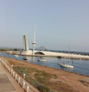 un grupo de barcos en el agua cerca de un puente en La Manga, PUERTOMAR, en La Manga del Mar Menor