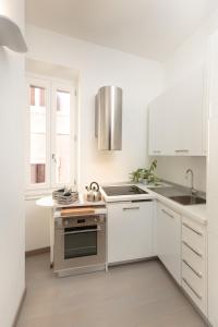 una cucina bianca con lavandino e piano cottura di Margana Tower a Roma