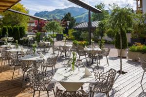 un restaurante con mesas y sillas en una terraza de madera en Hotel Zentral ****superior, en Kirchberg in Tirol