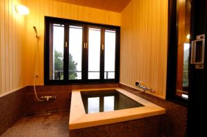 y baño con bañera y ventana. en Rakuyu, en Fujikawaguchiko