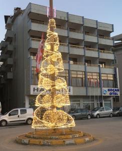 un arbre de Noël avec des lumières devant un bâtiment dans l'établissement KOÇAN OTEL Hatice Karakoçan, à Akçakoca