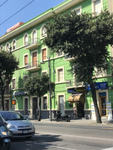 卡利亞里的住宿－Millefiori，一座绿色建筑,前面有停车位