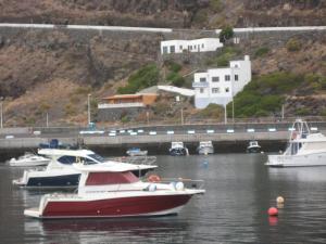 Tre barche sono ormeggiate in acqua vicino a un ponte. di Casa Puerto de la Estaca a Puerto de la Estaca