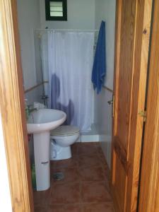 La salle de bains est pourvue d'un lavabo blanc et de toilettes. dans l'établissement Casa Puerto de la Estaca, à Puerto de la Estaca