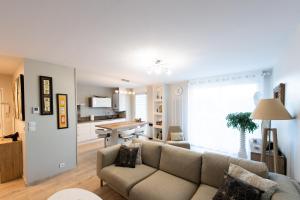 a living room with a couch and a kitchen at Bel'Apparté in Pau