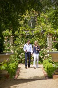 a man and a woman walking down a sidewalk at Jacobs Creek Retreat - Barossa Valley in Tanunda