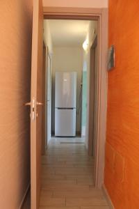 um corredor com um frigorífico branco numa casa em S'Olivariu Village Affittacamere em Piscinas