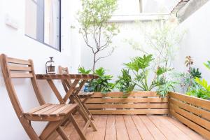 una silla de madera y una mesa en un balcón con plantas en 木本樹台南民宿 en Tainan