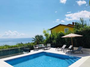einen Pool mit Stühlen und einem Sonnenschirm in der Unterkunft Villa Bardo in Opatija