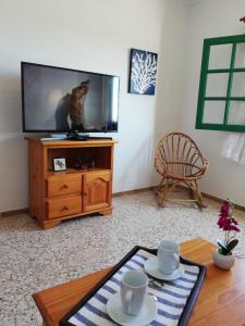 a living room with a tv and a table at Ocean Sunshine in Orzola