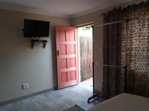 een kamer met een rode deur en een televisie bij 298 on 34th in Pretoria