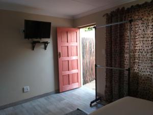 a room with a red door and a television at 298 on 34th in Pretoria