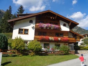 een huis met bloembakken aan de zijkant bij Ferienwohnung Bergblick in Schmirn