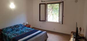 un dormitorio con una cama y una ventana en Résidence Palmarella, en Galeria