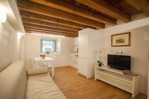 a living room with a couch and a television at Italianflat - Palazzo Rizzardi in Verona