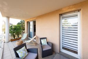 a balcony with two chairs and a window at Bel'Apparté in Pau