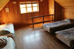 a room with three beds in a cabin with a window at Tatra Holiday House in Tatra